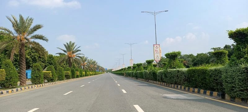 Wide asphalt Main Boulevard road infrastructure with commercial buildings in New Lahore City Lahore